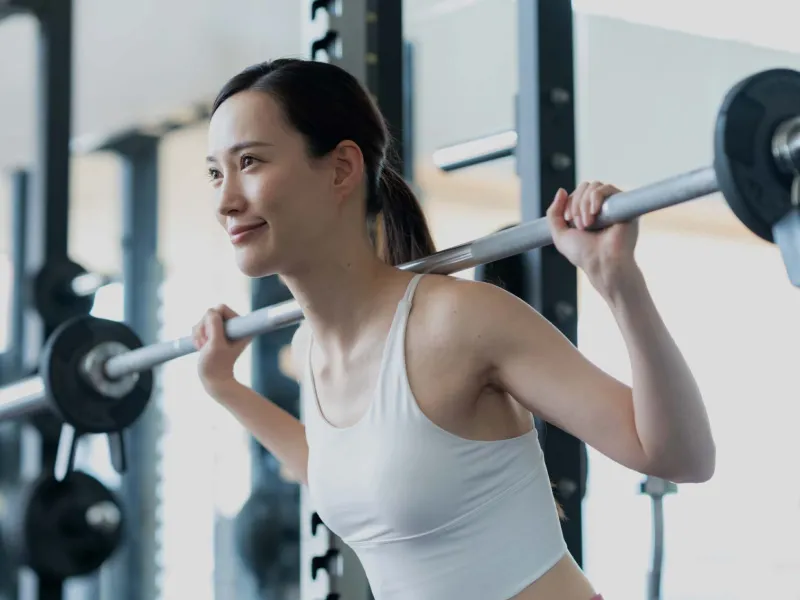 バーベルを使ったトレーニング中の女性のイメージ